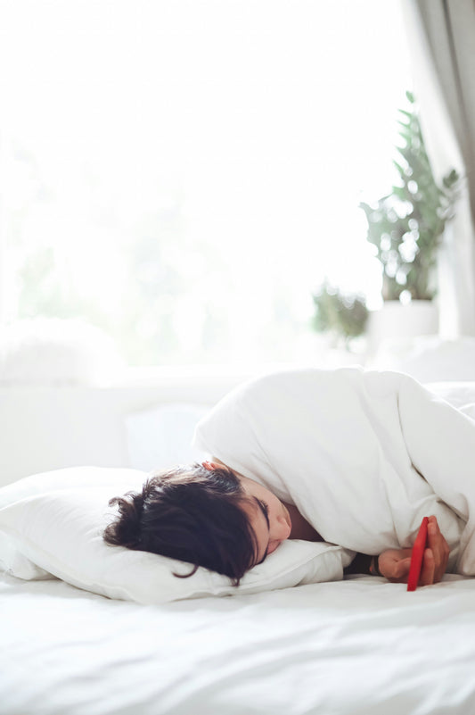 lady in bed scrolling on her phone